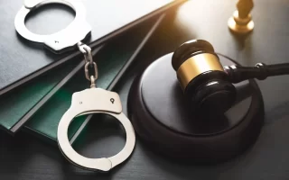 شرح انواع وکالت دعاوی کیفری و وظایف وکیل دادگستری| المان های حقوقی چکش و دستبند روی کتاب