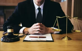 وظایف یک وکیل پایه یک دادگستری در جرم نشر اکاذیب| وکیلی در اتاقی با المان های حقوقی چکش و ترازو