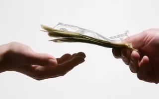 اجرت المثل| وکیل اجرت الامثل| دست دو نفر که در حال تبادل مبلعی پول و اسکناس هستند