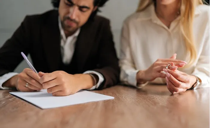 مدارک و مراحل قانونی طلاق از طرف مردـ صلح آفرین|مرد و زنی در اتاقی در حال نوشتن برگه طلاق